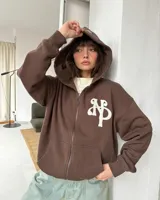 Campera con capucha y cierre frontal de Nude Project, color marrón, con corte boxy y diseño oversized. Presenta un parche bordado en relieve con las iniciales NP en el pecho, capucha amplia y bolsillos tipo canguro.