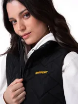 Chaleco acolchado de mujer marca Caterpillar, color negro, con cierre frontal de cremallera, bolsillos laterales con cierre y logo de la marca en el pecho.