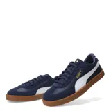 Championes urbanos Puma modelo Club II Era, color negro con detalles en blanco y suela de goma color marrón. Confeccionados en una combinación de cuero y gamuza, presentan el logo de la marca en dorado en el lateral.