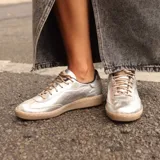 Championes de cuero metalizado color plata, con suela de goma color suela y cordones al tono.