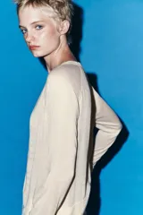 Jersey de punto verde militar con efecto doble, escote redondo y mangas largas con detalles en blanco en el cuello, puños y ruedo.