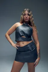 Minifalda gris de símil cuero con apliques de tres tiras con hebillas metálicas y cierre invisible atrás.