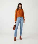Pantalón de jean modelo slim con cintura mediana, trabillas para cinturón y bolsillos funcionales. Presenta un diseño clásico con acabado en el bajo.