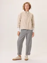 Pantalon de corte recto y tiro medio, confeccionado en tejido de lana con sutiles rayas verticales. Presenta bolsillos traseros aplicados, costuras reforzadas en las rodillas y ruedo con dobladillo.