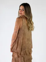 Top de viscosa color marrón tostado, sin mangas, con escote redondo y detalle de lazos para anudar en los hombros. Presenta un diseño de capas con volados en el ruedo.