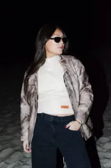 Campera de cuero hecha a mano con efecto marmolado en tonos grises y acentos envejecidos, de calce relajado y estructurado, con cuello alto y cierre frontal con cremallera.