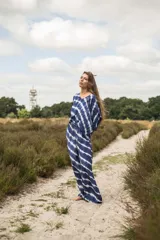 Pantalón de piernas anchas con estampado de rayas diagonales en azul y blanco. Elástico en la cintura con tirantes para anudar y bolsillos laterales.