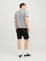 Short chino regular fit color negro, confeccionado en sarga de algodón con elastano, con dobladillo en las piernas y bolsillos laterales.