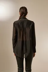 Camisa negra traslúcida de lyocell con cuello clásico, cierre frontal con botones y detalles de strass en cuello, botones y puños.