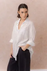 Camisa lila oversize de algodón con bordado floral calado tipo broderie, cuello camisero, manga larga y abotonadura frontal.