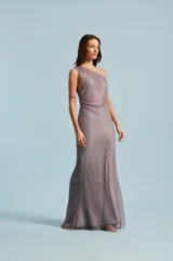 Vestido largo gris de un solo hombro, con diseño de malla brillante y silueta fluida.