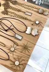 Collar con dije de sol dorado con centro de nácar, engarzado en un cordón fino color beige.