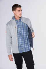 Campera deportiva de tejido tipo polar en color gris jaspeado, con cuello alto, cierre frontal completo, bolsillos laterales y bolsillo en el pecho con cierre. Presenta detalles en cuero sintético y logo bordado en el pecho.