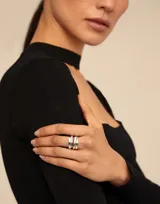 Anillo dorado de metal bañado en plata con diseño orgánico irregular.