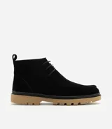 Bota tipo coturno de caña baja confeccionada en cuero gamuzado negro, con cierre de cordones, tirador en el talón y suela track de color tostado.