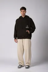 Buzo canguro oversize de algodón frizado con efecto gastado, capucha y bolsillo frontal tipo canguro. Presenta estampa gráfica sutil en el pecho.