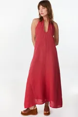 Vestido largo marrón de corte fluido y caída recta, con escote halter y tirantes anchos.