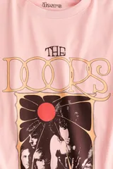 Remera oversize de algodón color rosado, con cuello redondo y diseño estampado frontal de la banda The Doors.
