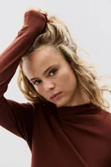 Top de punto suave con cuello alto y mangas largas, de diseño entallado.