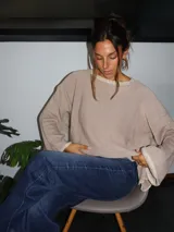 Sweater tejido de punto jersey en color negro, con terminaciones hechas a mano en crochet a contratono con detalles de lurex. Presenta una silueta oversize, mangas acampanadas y cuello a la base.