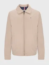 Campera Tommy Hilfiger color beige con cierre de cremallera, cuello doblado y dos bolsillos laterales. Tiene detalles distintivos de la marca y el logo bordado en el pecho.