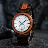 Reloj Chenaut Perle d’Ébène con caja de madera de sándalo rojo, esfera blanca perlada con manecillas azules y malla de madera de ébano.