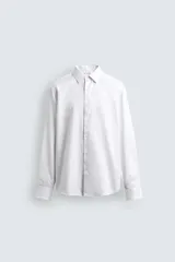 Camisa de corte slim fit confeccionada en tejido de algodón. Presenta cuello italiano, manga larga con puños abotonados y cierre frontal mediante botonadura clásica.
