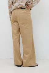 Pantalon de corte recto y tiro alto, confeccionado en un tejido de acabado suave y textura aterciopelada, con costuras verticales decorativas en el frente.