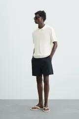 Polo de punto canalé color rosado, de corte regular fit, con cuello solapa y cierre frontal de botonadura. Manga corta y acabados en rib.