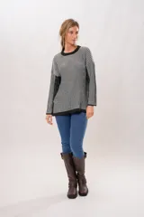 Sweater de punto con cuello redondo y mangas largas. Diseño a rayas verticales en tonos gris y negro.