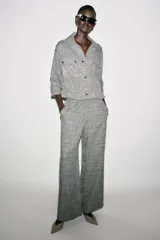 Pantalón de tiro alto color gris jaspeado, con cintura elástica y pernera ancha.