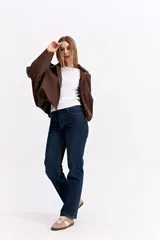 Campera de gamuza sintética color verde oliva, con silueta amplia, hombros caídos y cierre frontal. Presenta un diseño estructurado con volumen en mangas y cuerpo.