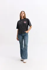 Remera de corte oversize color verde agua con efecto acid wash, cuello redondo y estampa pequeña en el pecho. Presenta una silueta relajada y mangas cortas.