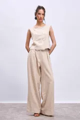Pantalón de lino color beige, de corte palazzo con pinzas en la cintura.