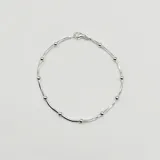 Pulsera semirrígida de plata 925 compuesta por tres cadenas de diferentes estilos: una cadena de eslabones ovalados, una cadena de esferas pequeñas y una cadena de eslabones tipo rolo.