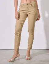 Pantalón jean skinny color beige de tejido stretch, con pretina con pasadores, botón y cierre, y bolsillos delanteros y traseros.