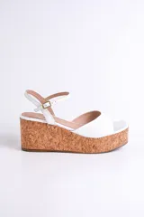 Sandalias plateadas con plataforma de corcho, tira delantera ancha y tira fina con hebilla alrededor del tobillo.