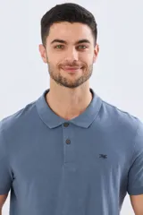 Remera polo de manga corta en color azul melange, con cuello camisero, cierre frontal de dos botones y pequeño bordado en el pecho.