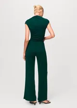 Pantalón de vestir color verde oscuro, de corte wide leg y tiro medio. Presenta cintura con elástico, pinzas delanteras y diseño largo.