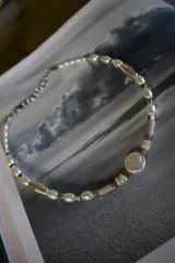 Gargantilla de perlas de río blancas y cuentas de diferentes formas y colores, con cierre de mosquetón plateado.