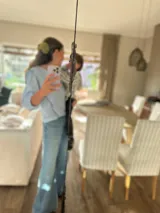 Camisa celeste a rayas verticales blancas, con cuello en V y mangas 3/4 abullonadas.