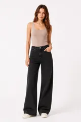Pantalón jean gris oscuro de tiro medio y corte ancho, con bolsillos frontales y traseros, y cierre de botón y cremallera.