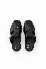 Zapatos de cuero marrón estilo fisherman con diseño cerrado en la parte delantera, tiras cruzadas y hebilla lateral ajustable.
