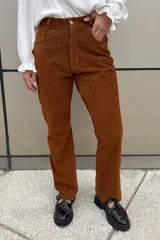 Pantalón de cuero ovino italiano color crema, de corte recto con tajos laterales en el ruedo.