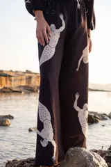 Pantalón amplio negro con estampado de sirenas en color crema, cintura elastizada y silueta fluida.