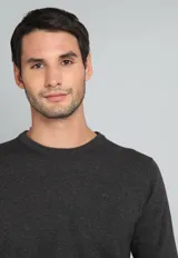 Sweater de algodón color verde petróleo, con cuello redondo y mangas largas.