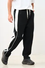 Pantalón de jogging negro con franjas blancas laterales y cordón ajustable en la cintura.