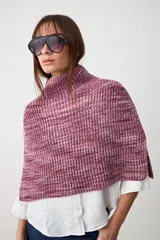 Capita tejida en punto acanalado, con cuello alto y diseño corto tipo poncho.