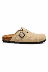 Zueco de diseño cerrado con puntera redondeada, confeccionado en material texturizado color beige, con tira ajustable y hebilla metálica lateral. Posee suela anatómica de corcho y base de goma antideslizante.