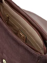 Cartera tipo bandolera de gamuza color bordó, con solapa frontal y detalle de cierre con hebilla decorativa en cuero marrón. Cuenta con correa ajustable y herrajes metálicos dorados.